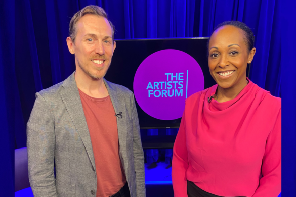 Two hosts in front of The Artists Forum purple logo on a television studio set