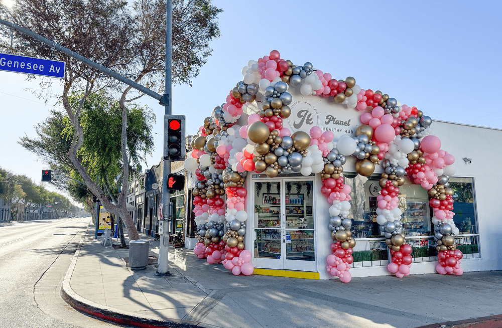 West Hollywood corner storefront wrapped in a pink, silver and gold balloon arch