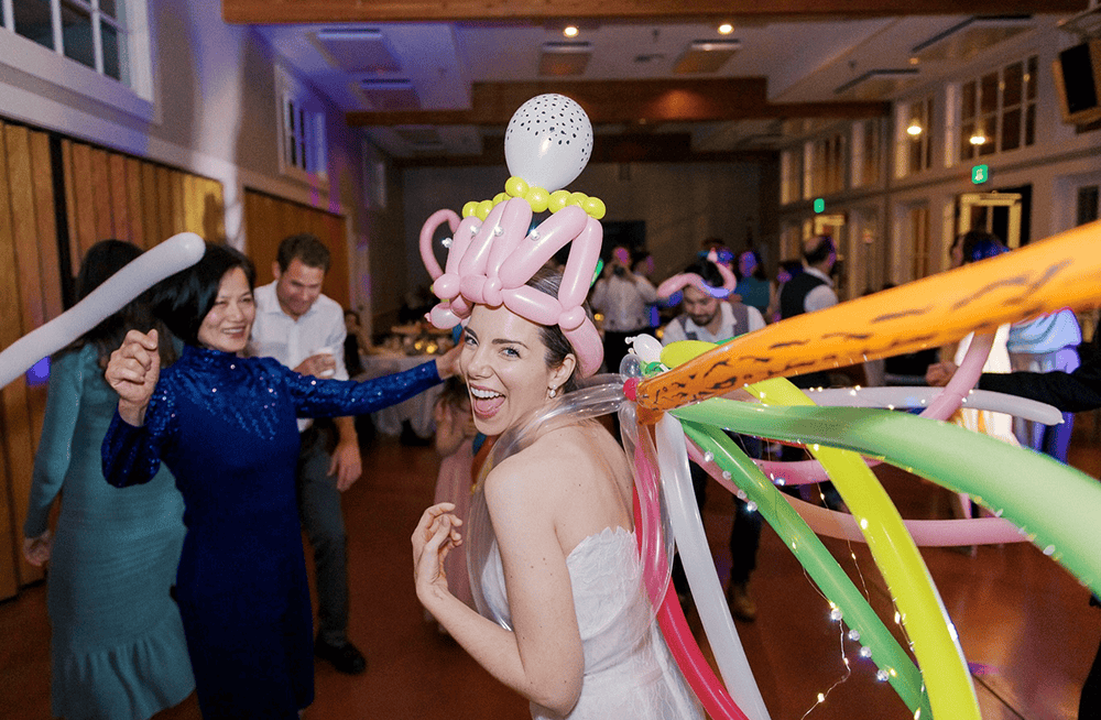 Bride wearing a twisted balloon hat and garland on a wedding reception dance floor