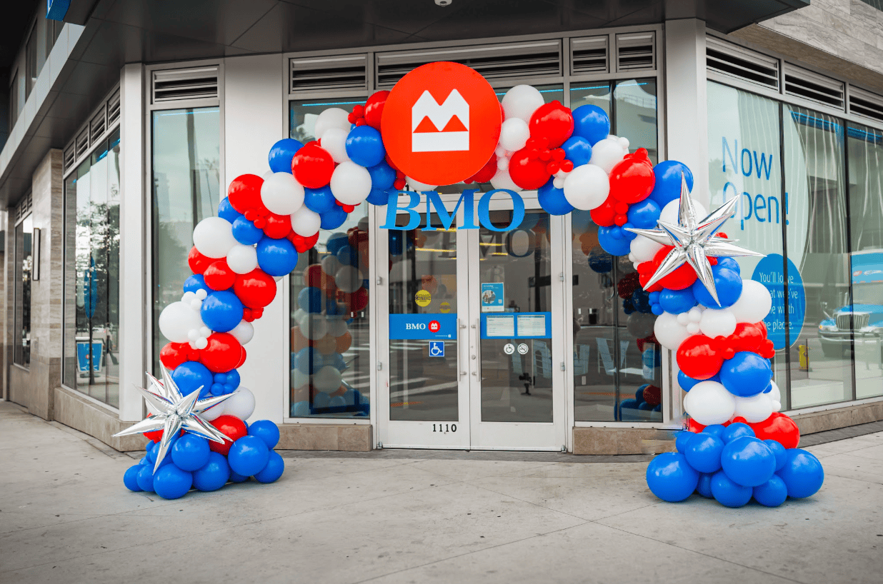 BMO bank grand opening with a red, white and blue balloon arch over the entrance