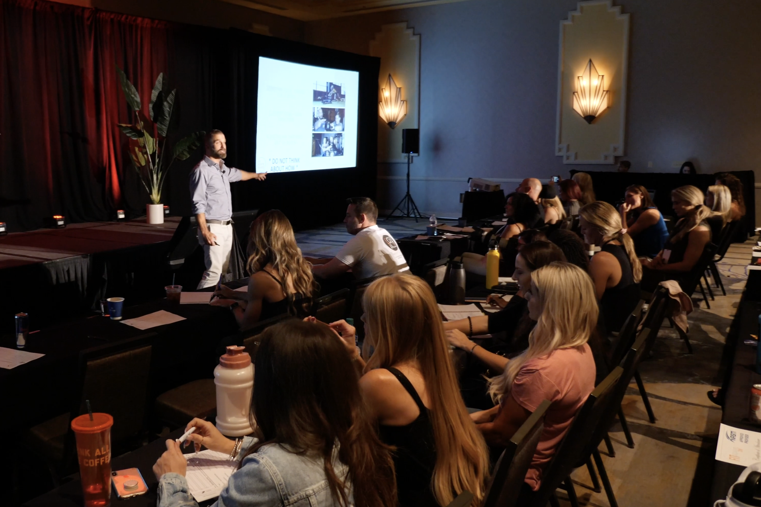 Billy Polson pointing at a projection screen during a ballroom workshop with rows of attendees