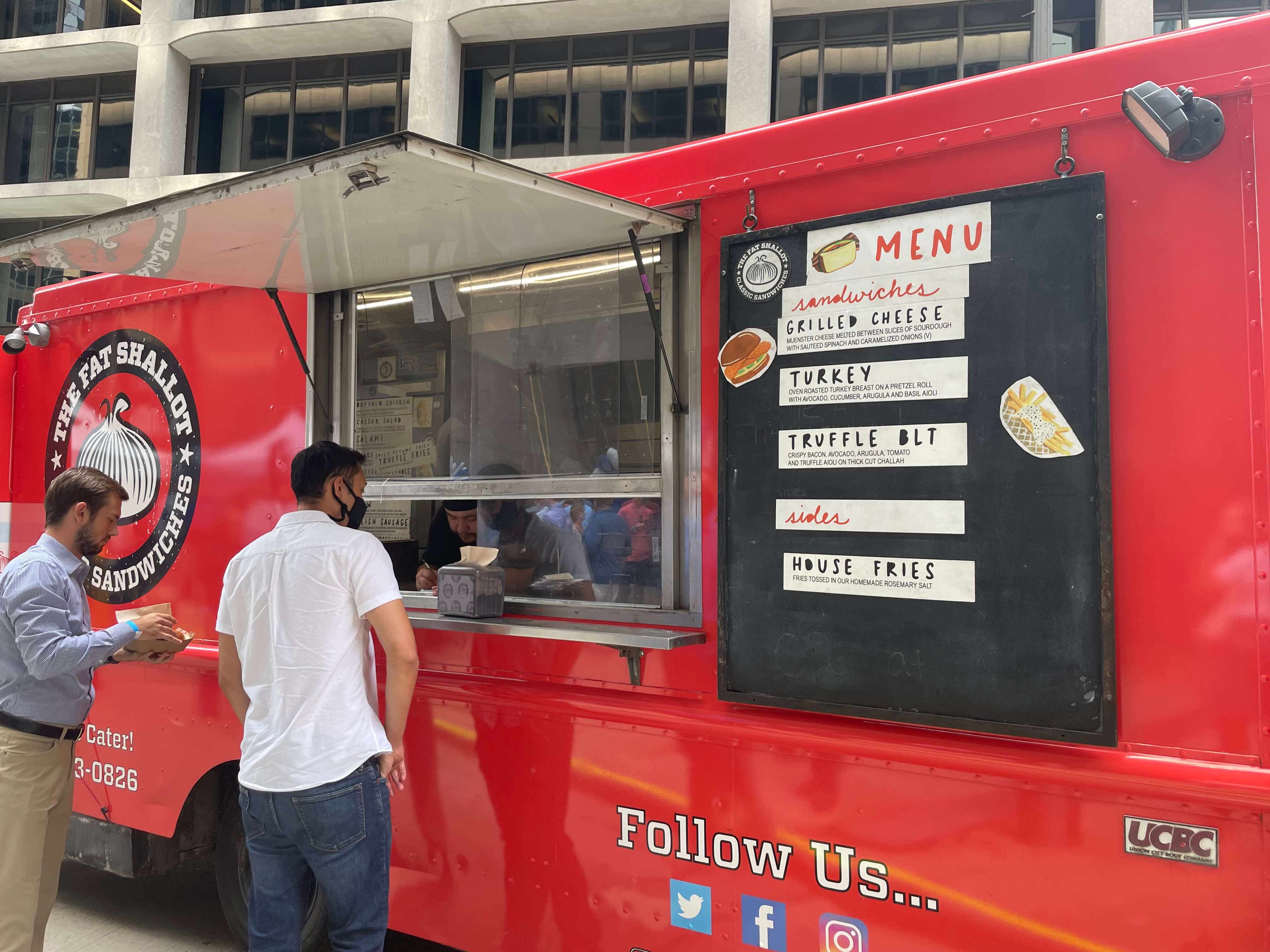 Red food truck (The Fat Shallot) on an urban street with customers ordering at the service window
