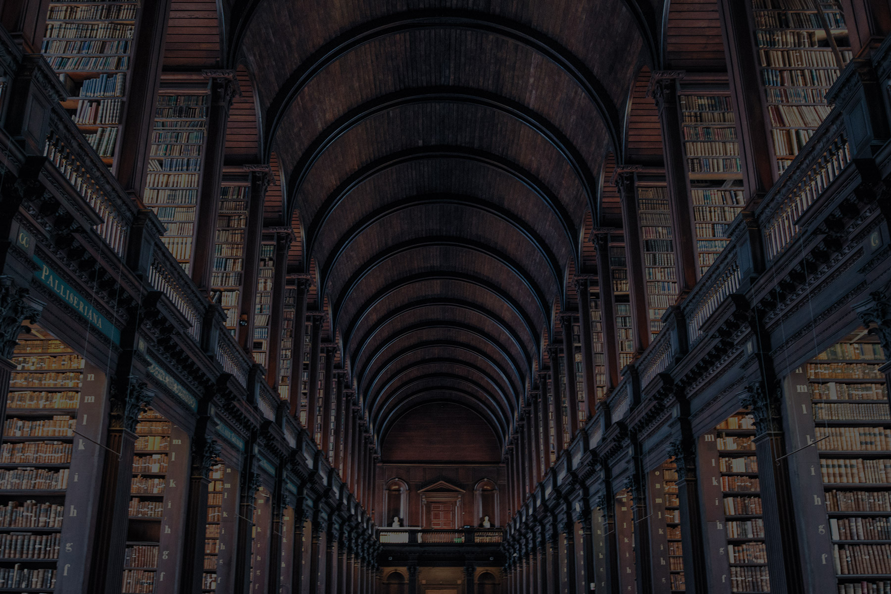 Grand historic library hall with tall arched ceilings and floor-to-ceiling bookshelves