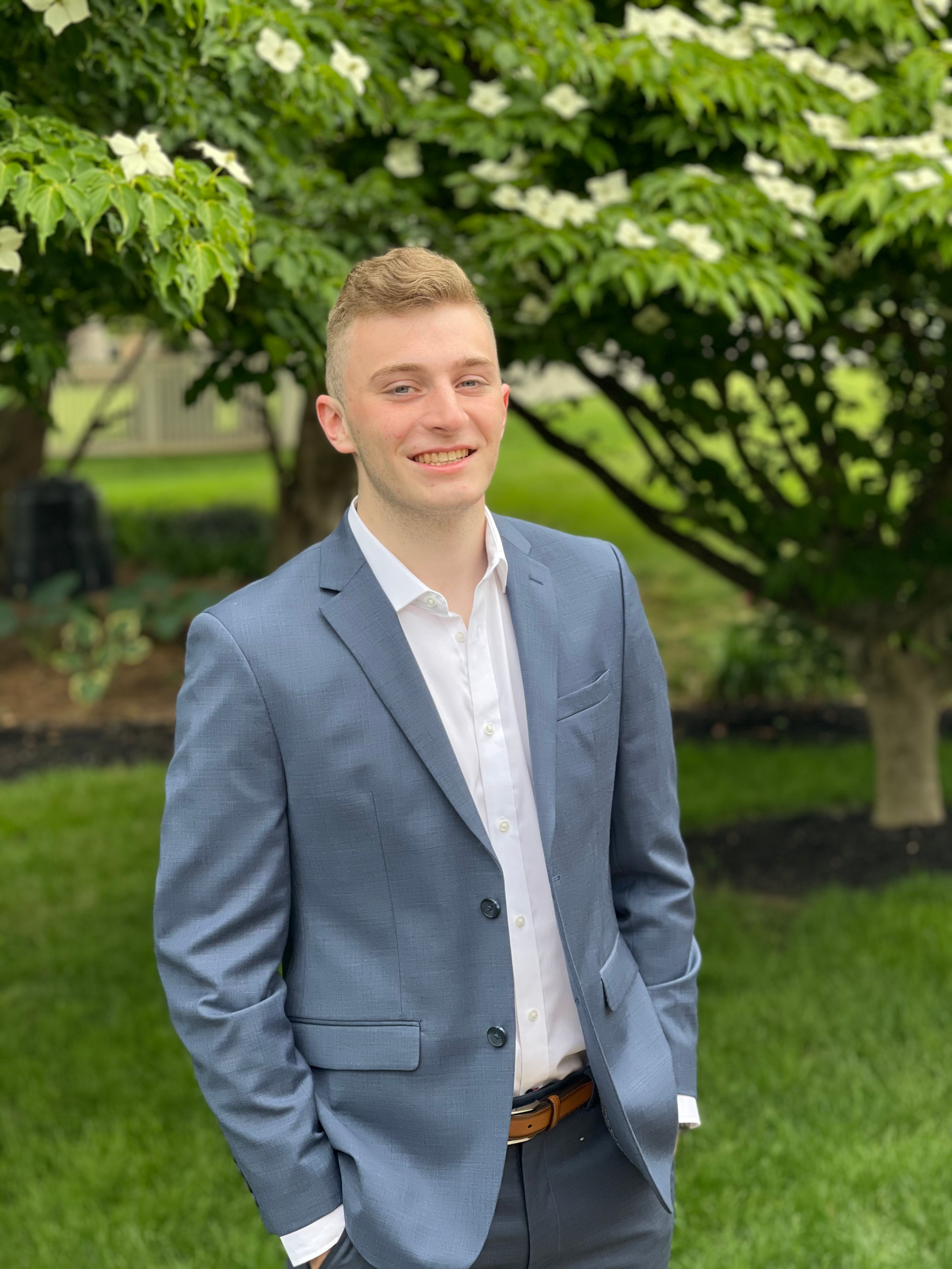 Justin Baker, smiling in a blue suit jacket outdoors