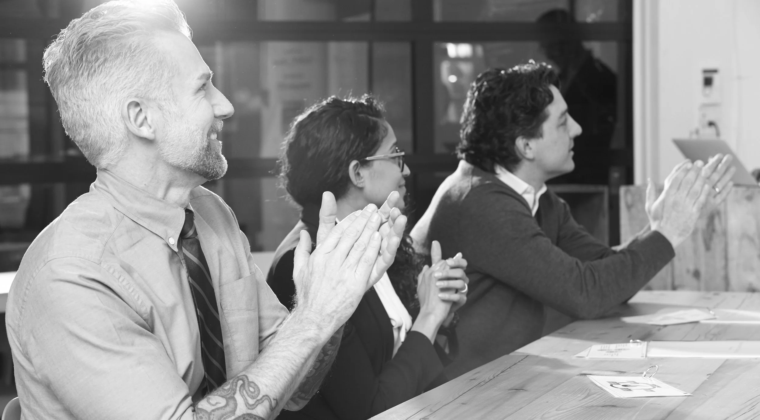 Three professionals clapping and applauding at a workshop session