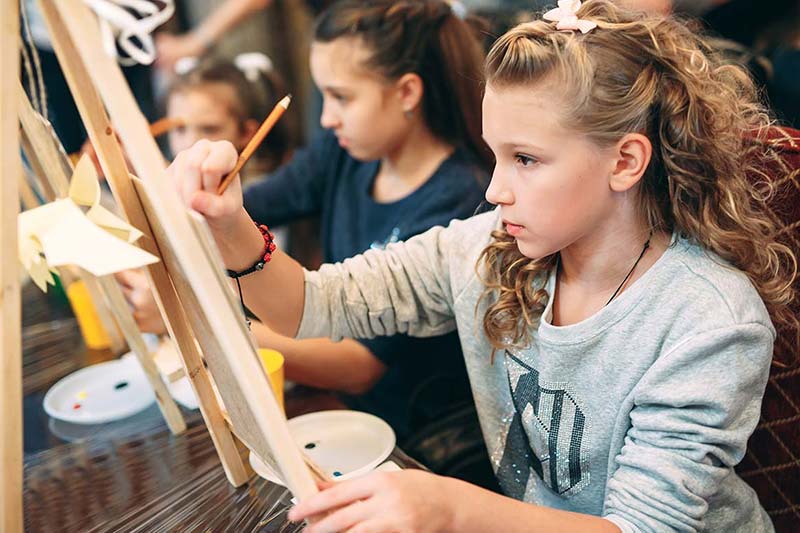 Youth art class painting at easels
