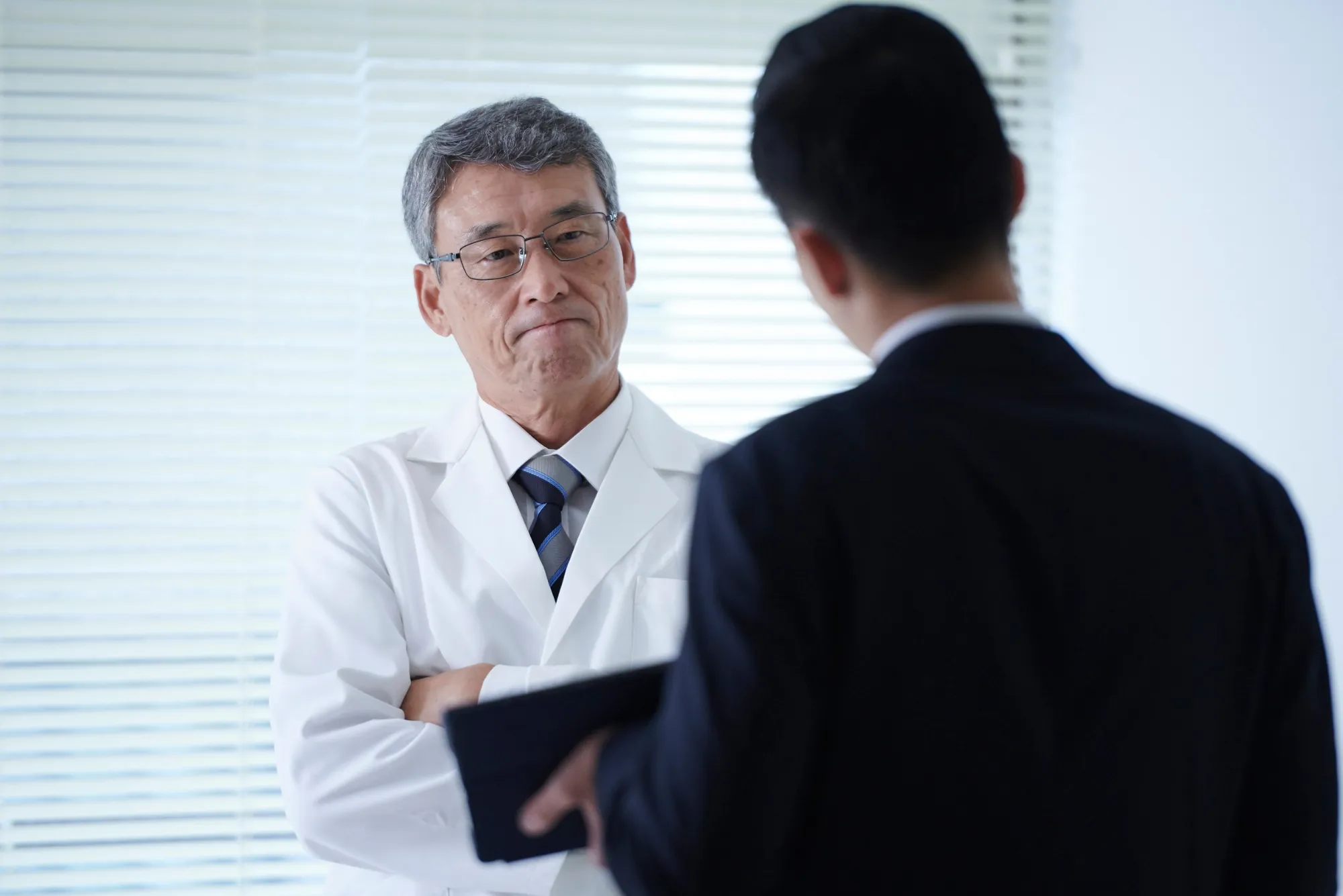 Senior physician consulting with a business executive