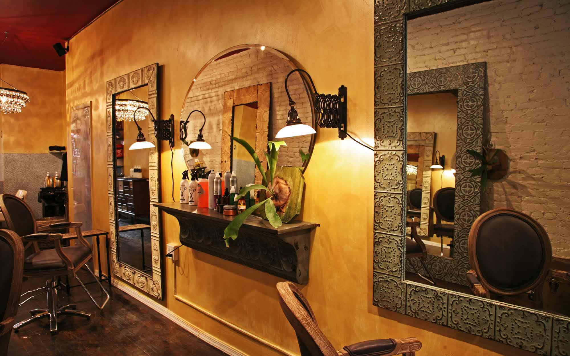 Salon interior with ornate mirrors, wall sconces and warm golden walls