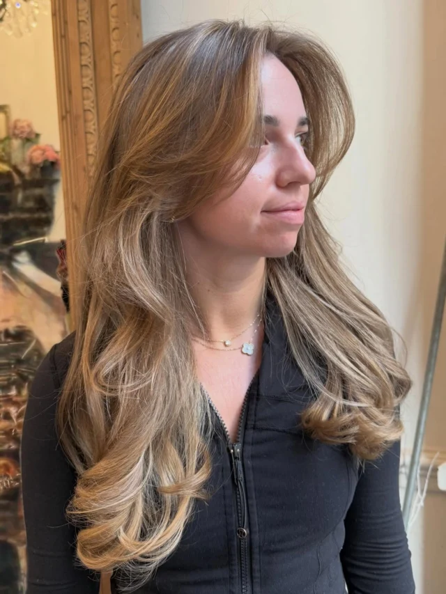 Client with long wavy balayage highlighted hair