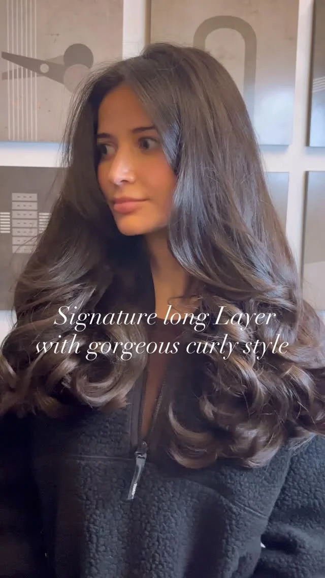 Client with a signature long layered curly style