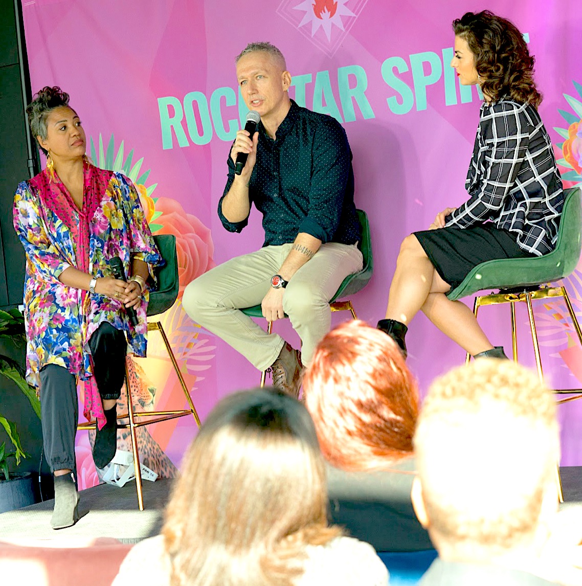 Panel discussion with three speakers before a Rockstar Spirit backdrop
