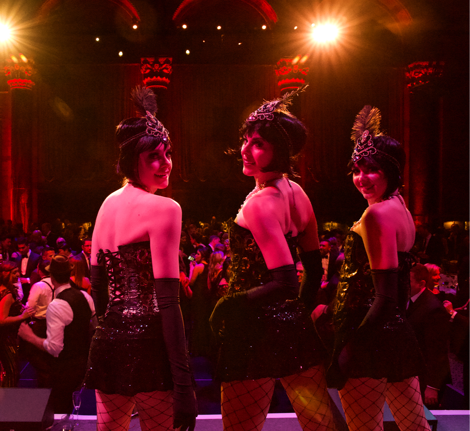 Flapper-style performers in black sequin costumes with feather headpieces
