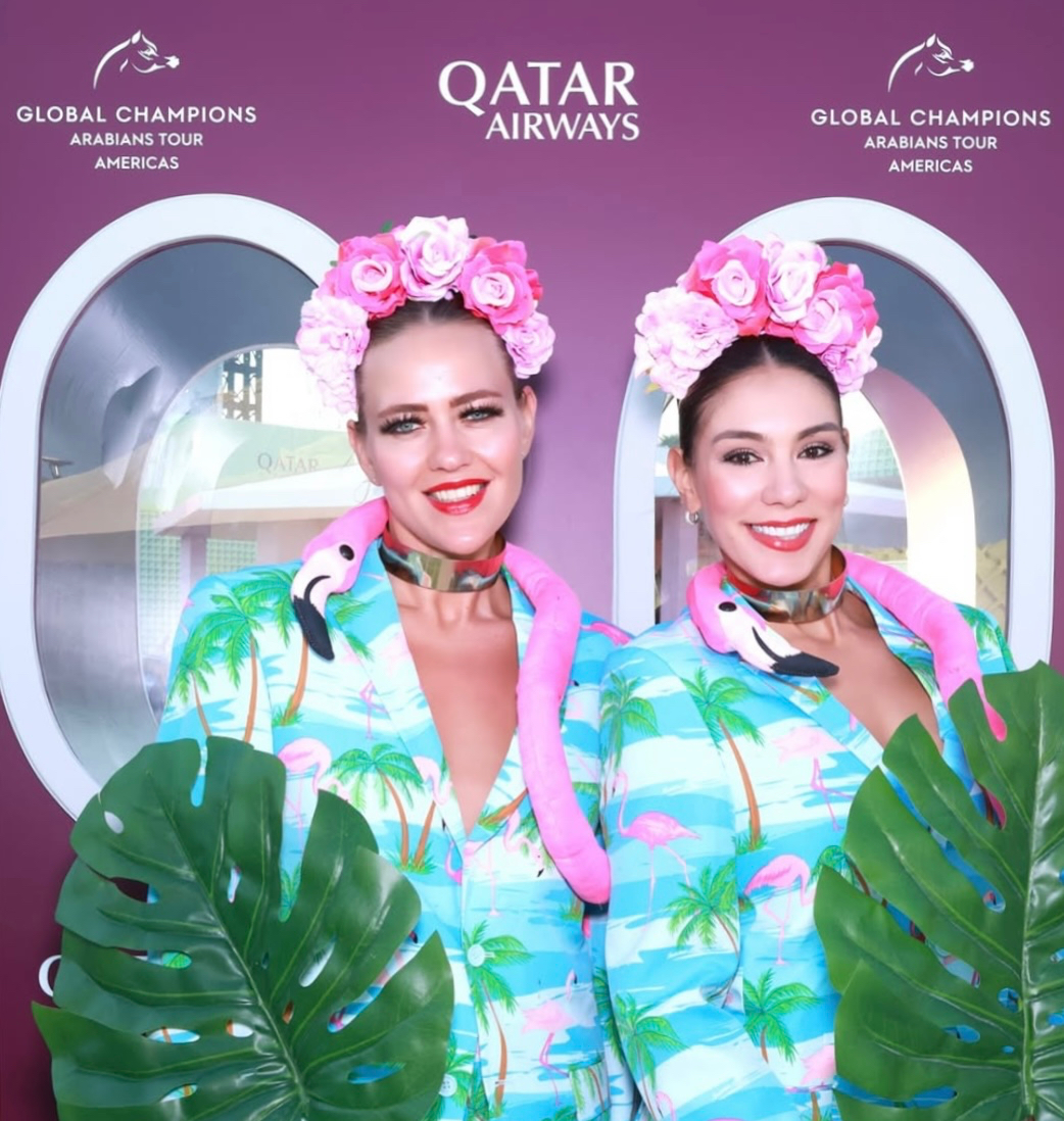Performers in tropical outfits at a Qatar Airways Global Champions Tour backdrop