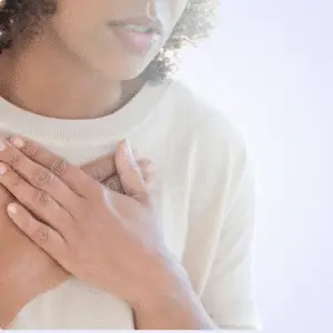 Person with hands clasped over their chest, softly focused