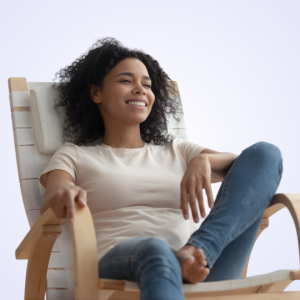 Young woman relaxing in a rocking chair, smiling