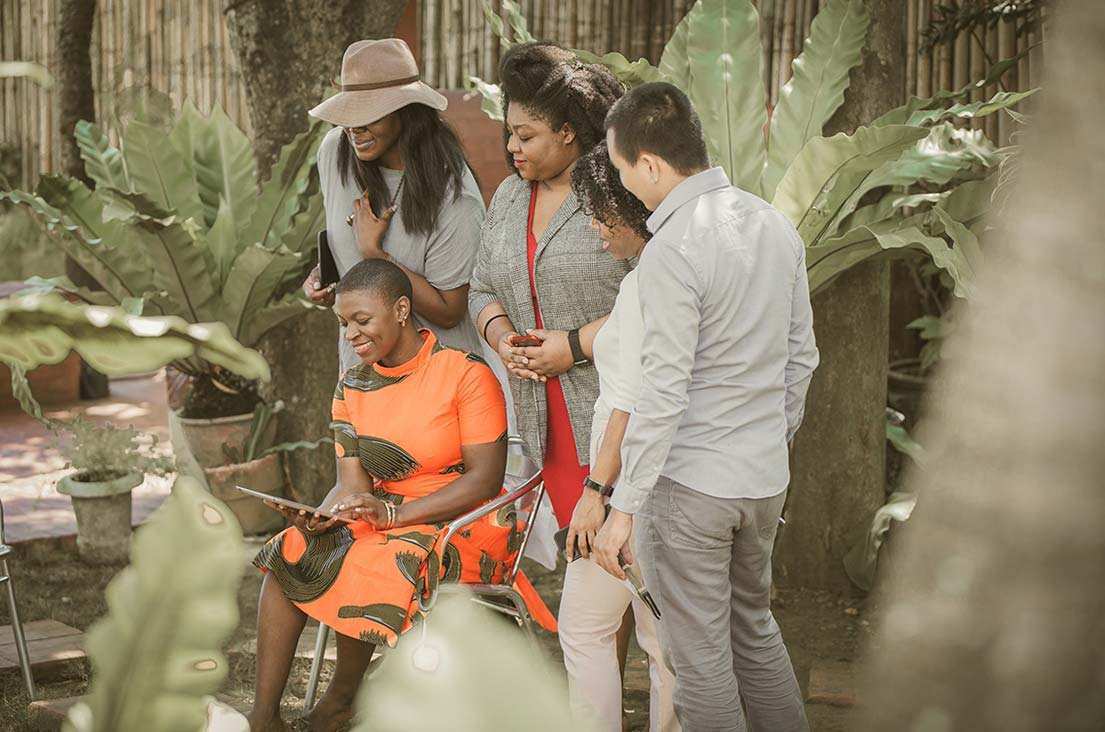 A diverse group of four professionals collaborating outdoors at a corporate retreat
