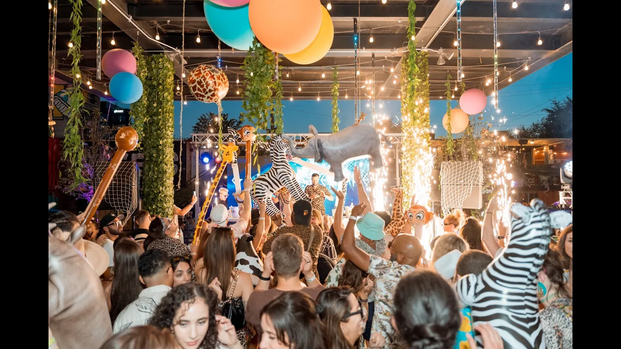 Safari-themed Vibeapple pop-up party with performers, sparklers and a large crowd
