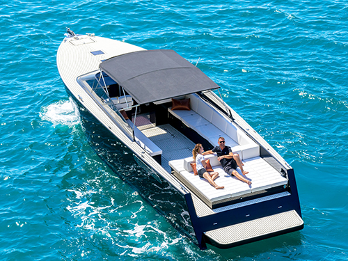 Couple relaxing on the deck of a luxury speedboat on blue water