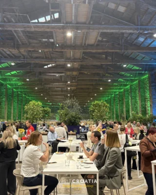Instagram post: large indoor event and dining hall with green lighting