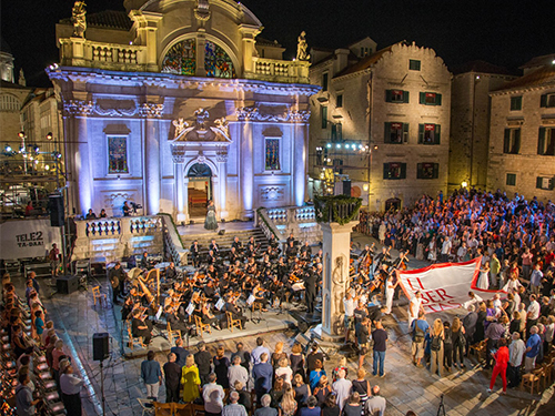 Outdoor orchestral concert in a historic town square at night