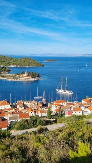 Instagram reel: aerial view of a Croatian island town harbour with a sailing yacht