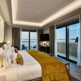 Instagram post: luxury hotel room with gold bedspread and a sea-view balcony