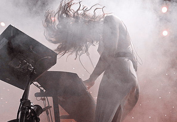 Silhouette of a woman at a keyboard on a foggy stage — the Julie Ann archetype