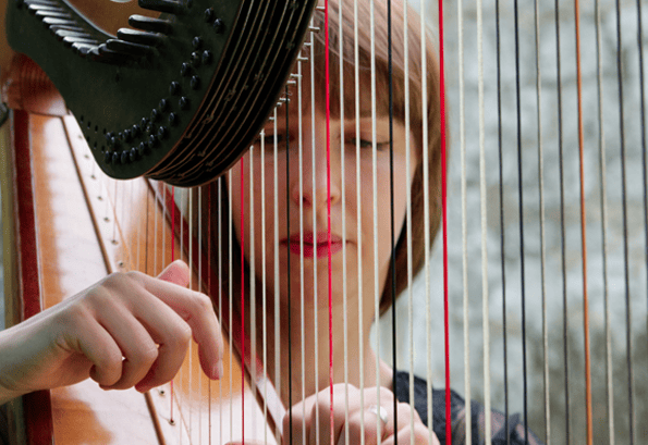 Woman playing harp close-up — the Tessa archetype
