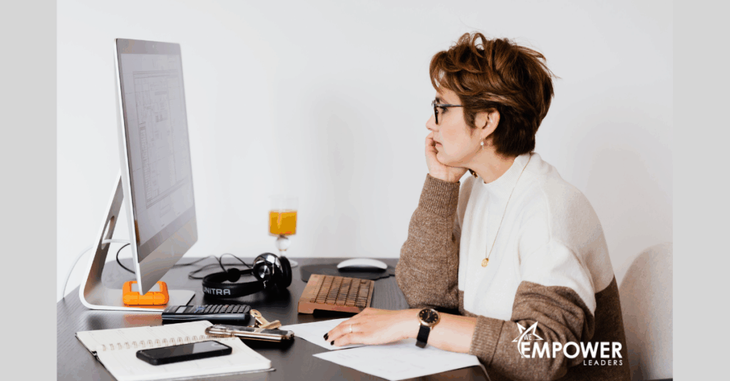 Woman with glasses working at a desktop computer
