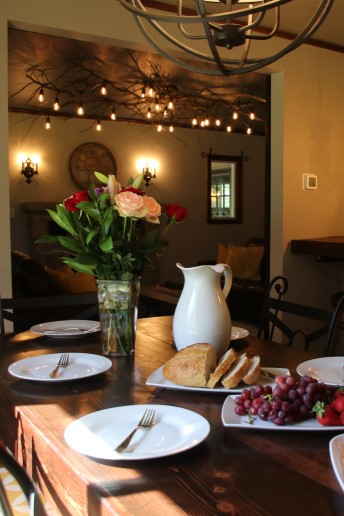 Cozy dining room at the Water Dragon Inn with a rustic wood table set with flowers, bread and fruit