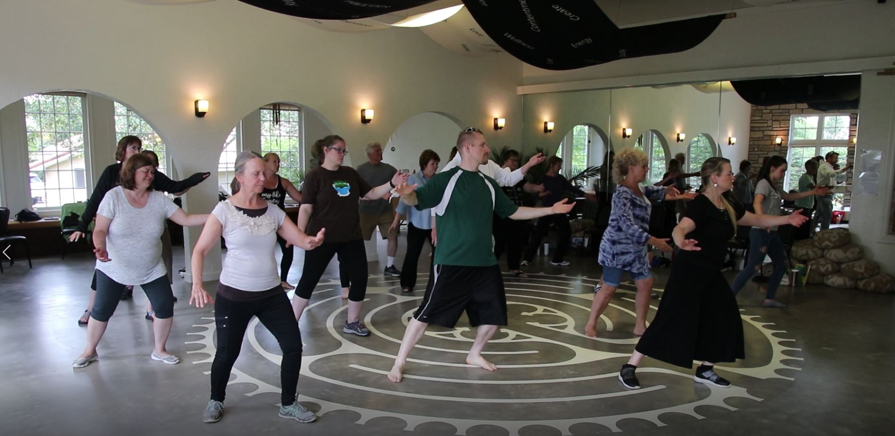 Adults moving together in the studio on the labyrinth floor design