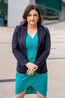 Wendy Paige Sterling in a dark blazer over a teal wrap dress