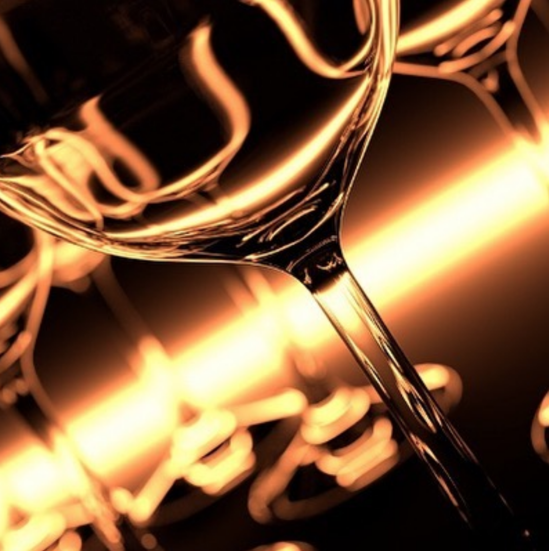 Macro close-up of wine glasses lit in warm golden light