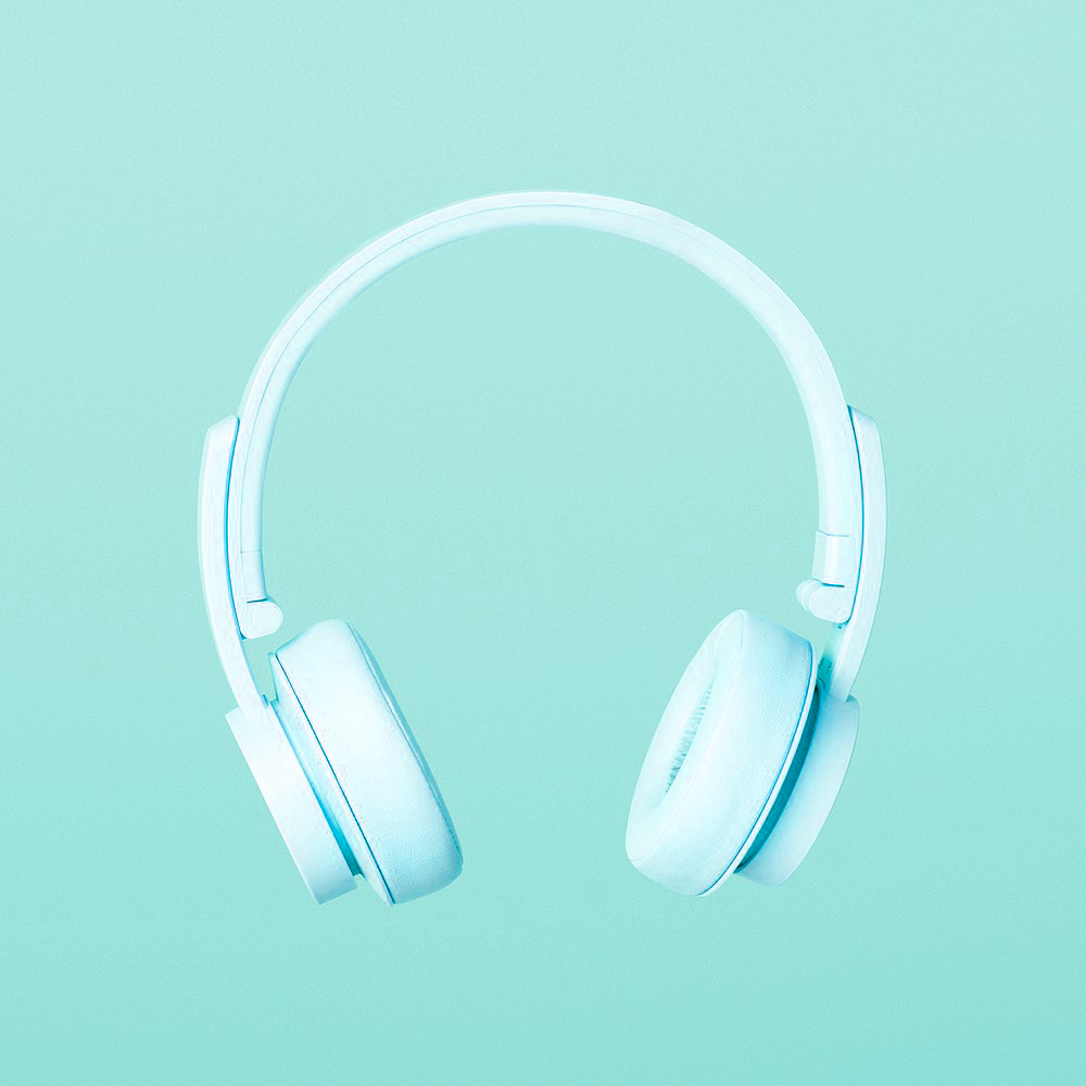 Mint-coloured wireless headphones on a matching mint background