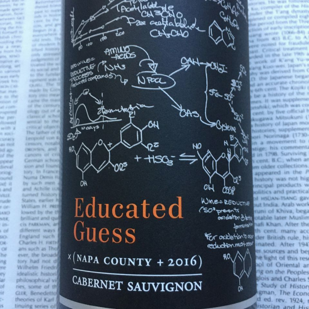 Educated Guess Napa County 2016 Cabernet Sauvignon label resting on an open book
