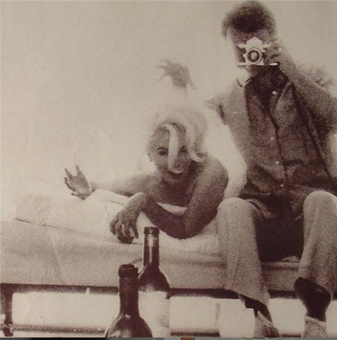 Sepia vintage photo of a woman on a sofa with wine bottles and a man holding a camera