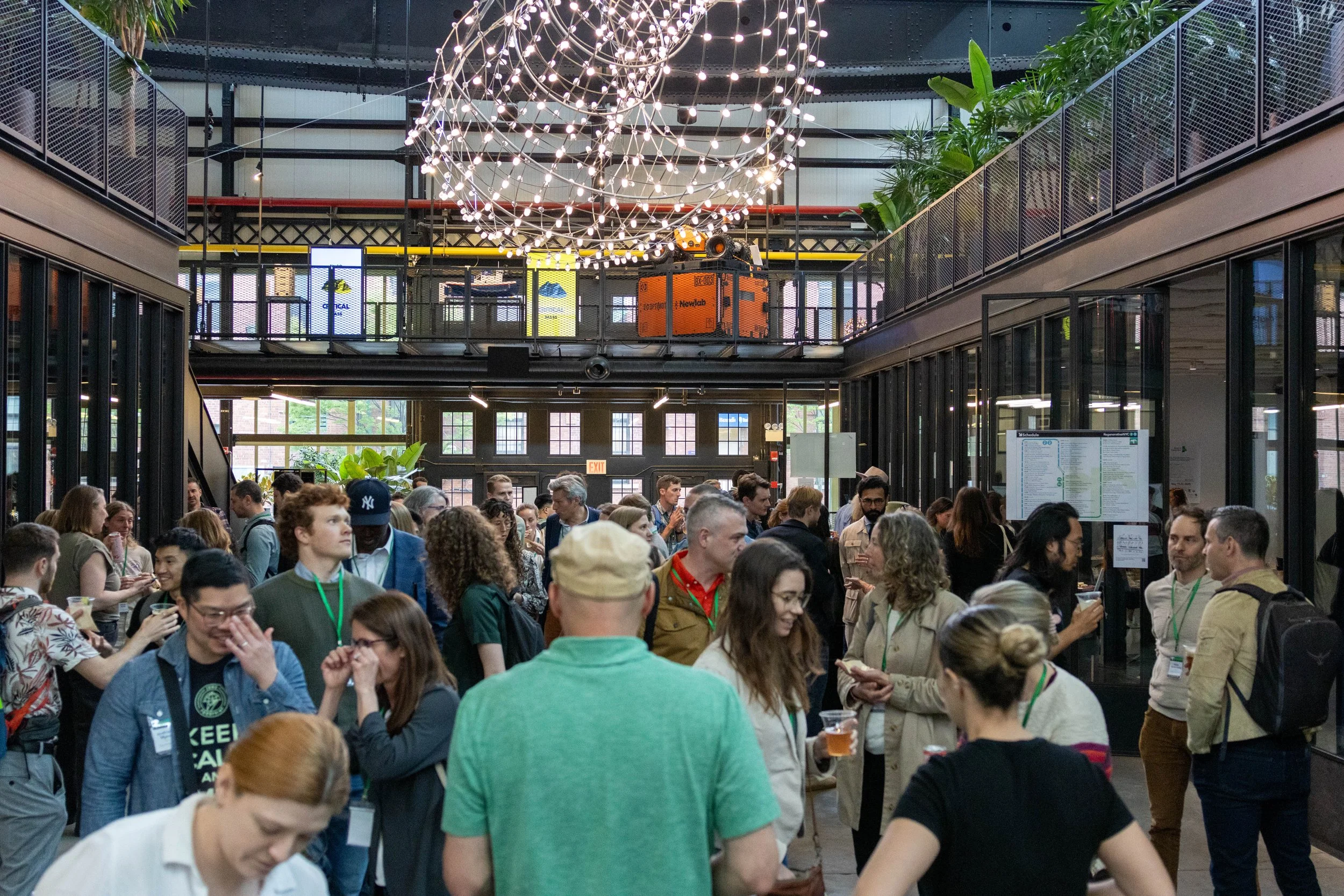 Attendees networking inside the industrial atrium venue at a Why Regenerative event