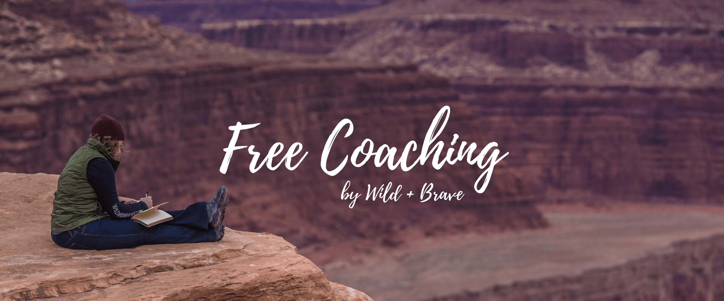 Woman journaling on a red-rock cliff overlooking a canyon, with the hand-lettered words Free Coaching by Wild + Brave