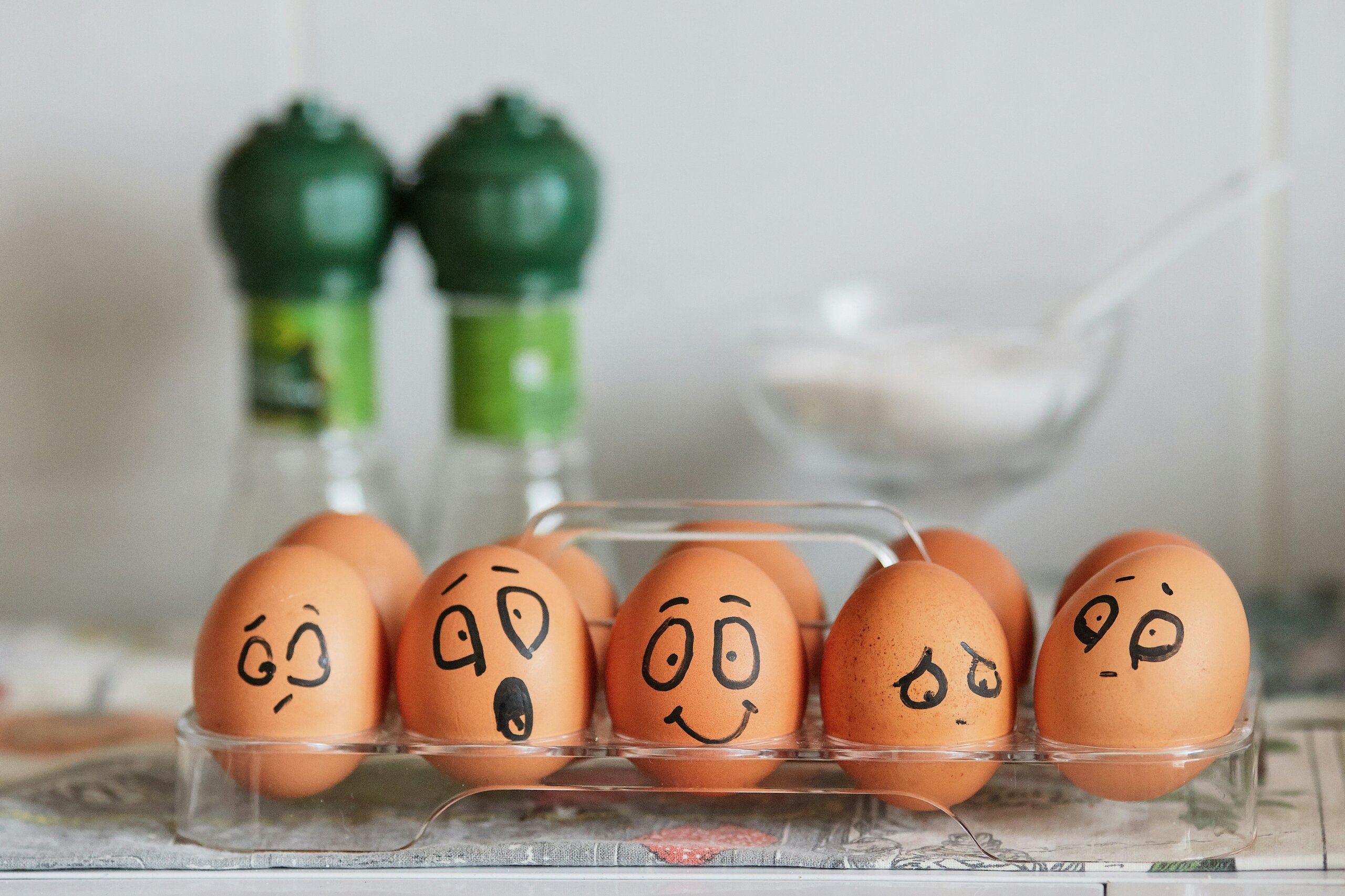 Eggs with hand-drawn cartoon faces in an egg tray