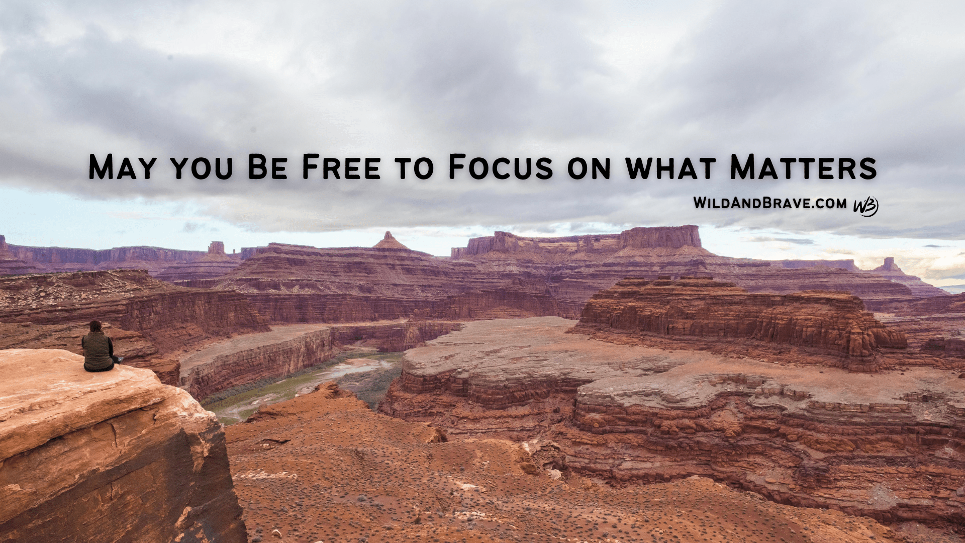 Canyonlands panorama with a lone figure on a cliff