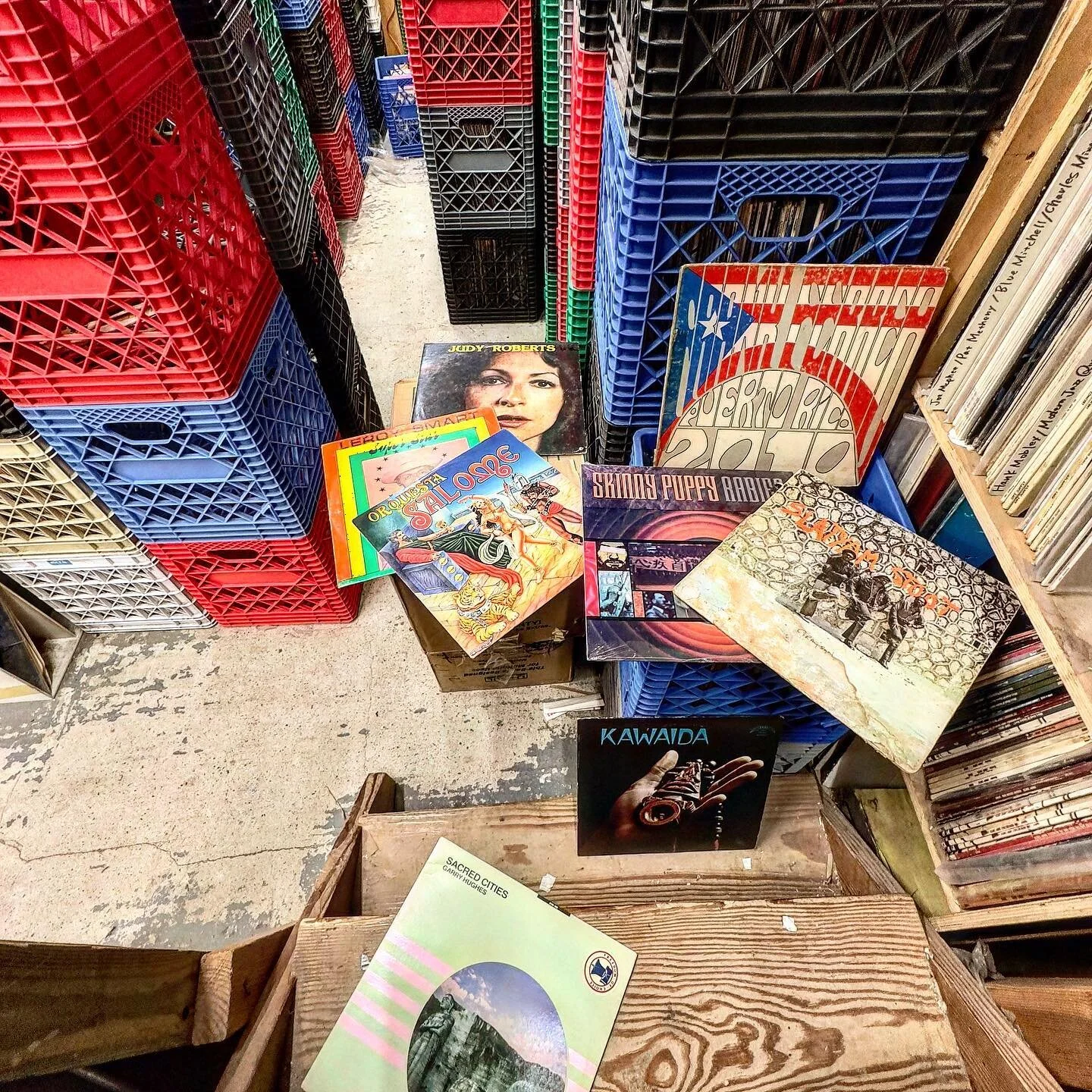 Overhead view of colorful milk crates and album covers piled on the store floor