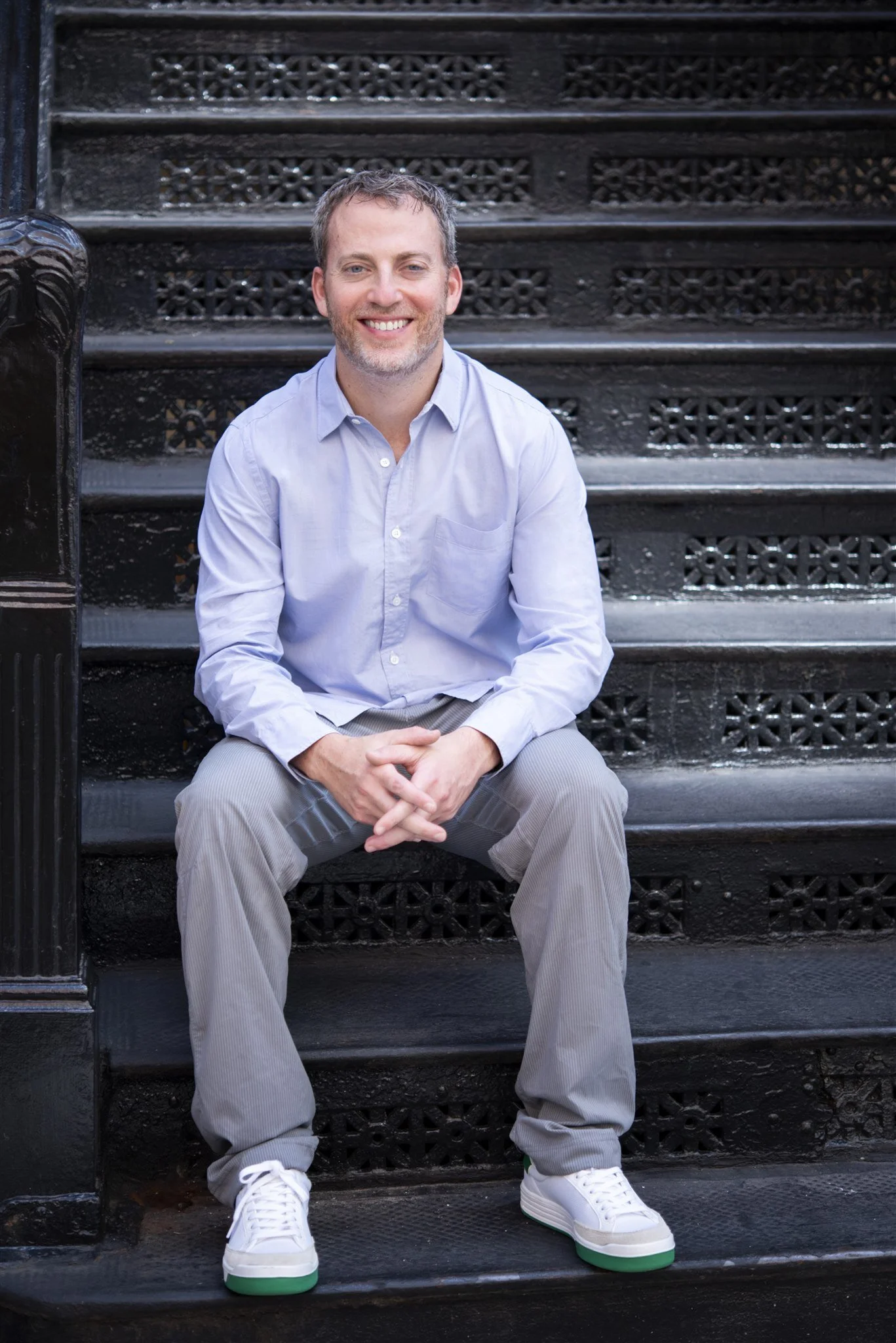 Gabriel Sher, L.Ac., seated on a Flatiron brownstone stoop