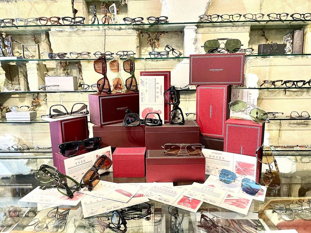 Red Jacques Marie Mage boxes and sunglasses arranged on the shop display counter