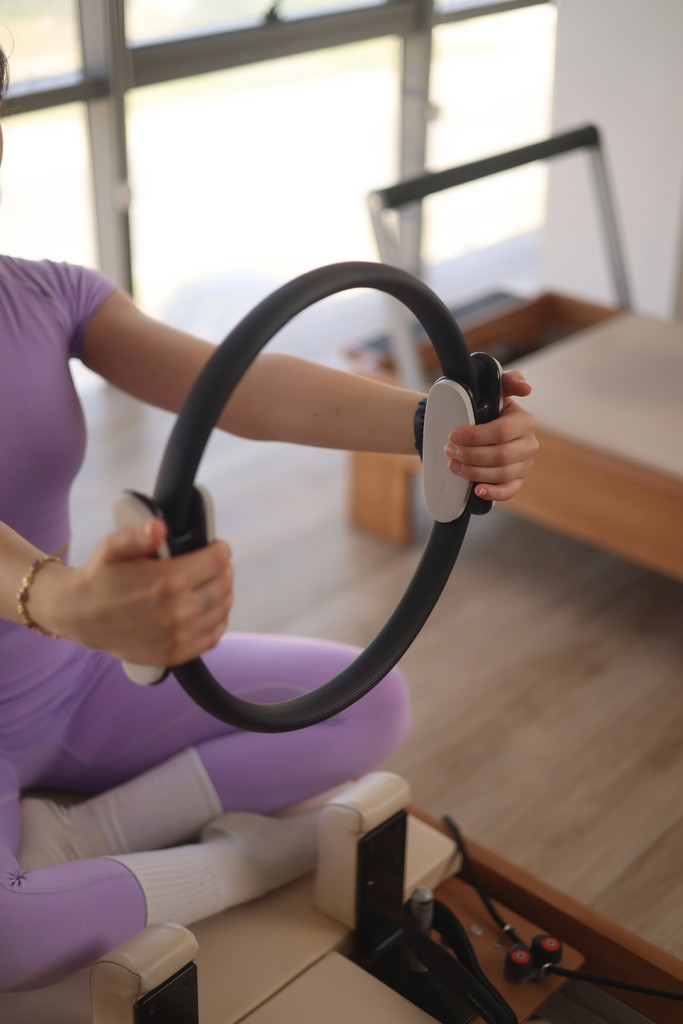 Woman in purple activewear holding a pilates ring
