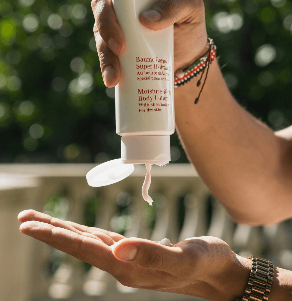 Hands dispensing moisture-rich body lotion outdoors