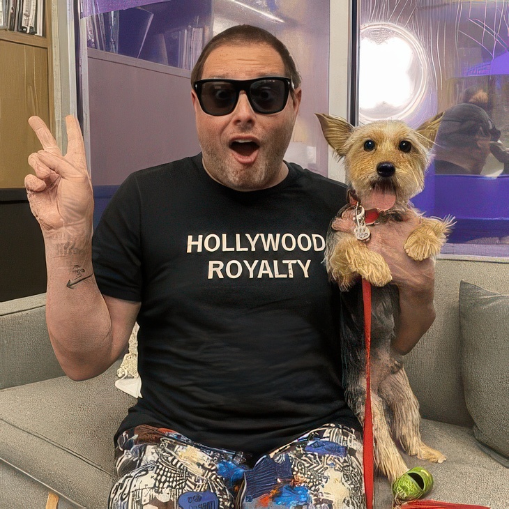 Customer in a Hollywood Royalty t-shirt holding a Yorkshire Terrier at DOGMA
