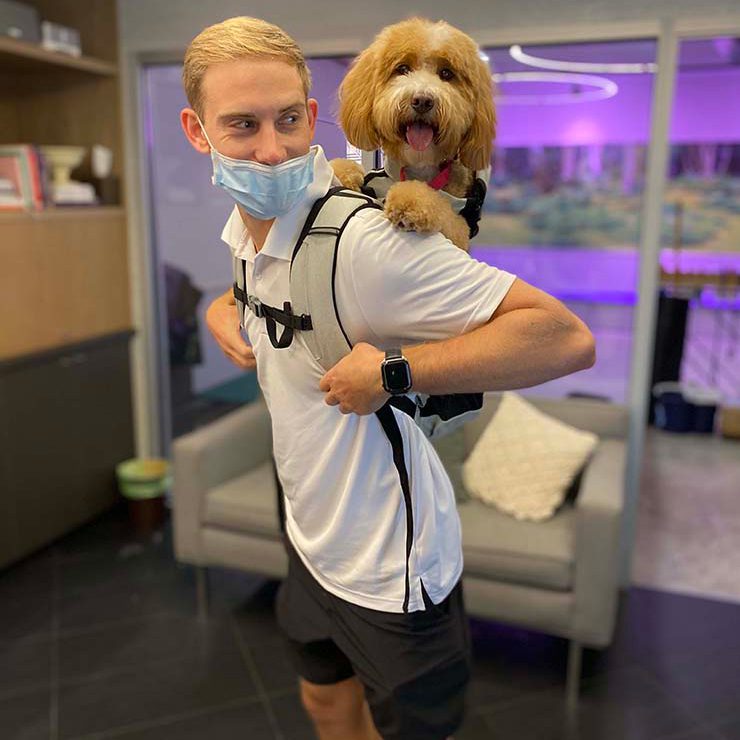 Customer carrying a golden doodle in a dog backpack inside DOGMA