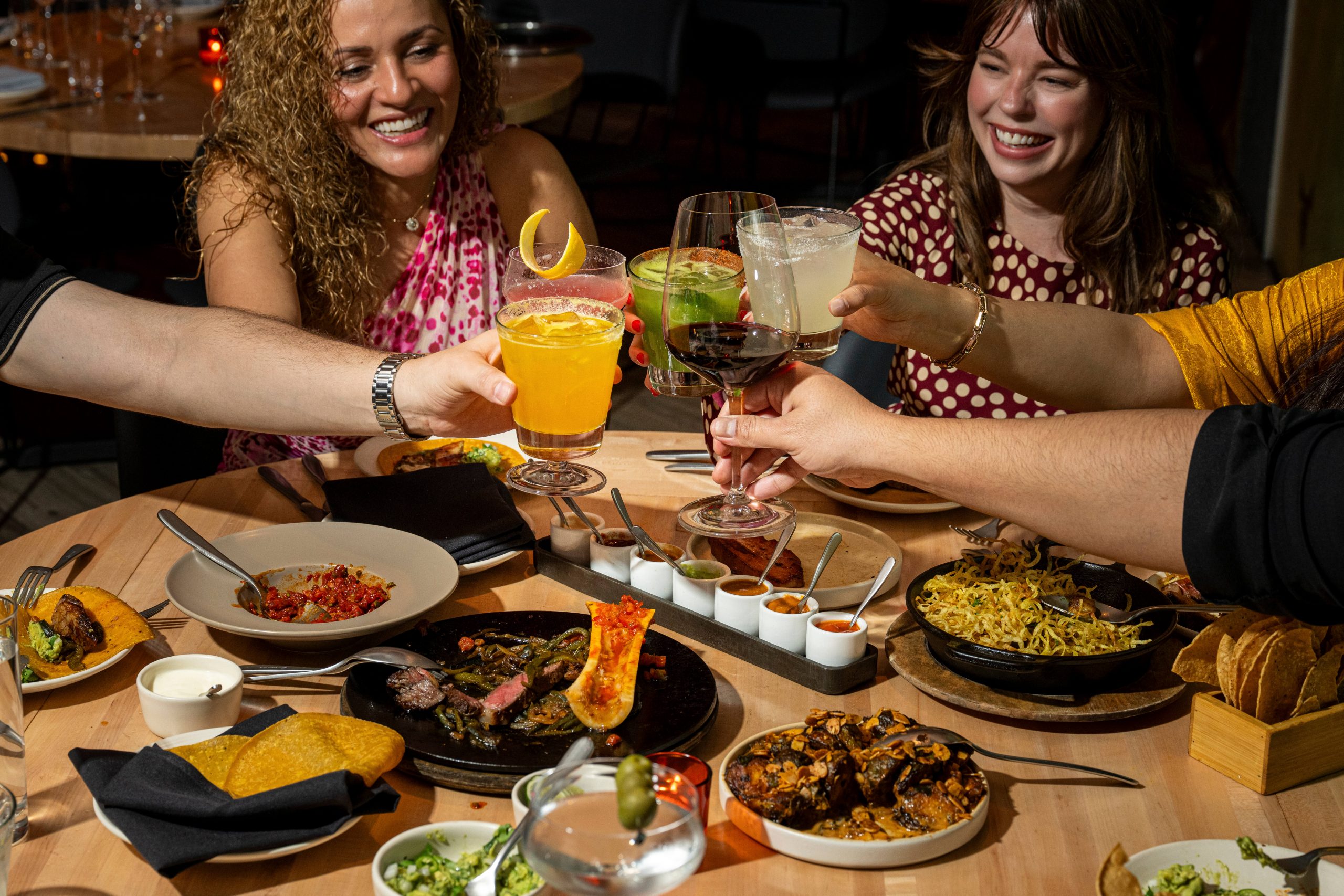 Guests raise their glasses over a table of tacos and shared plates at Empellón, 510 Madison.