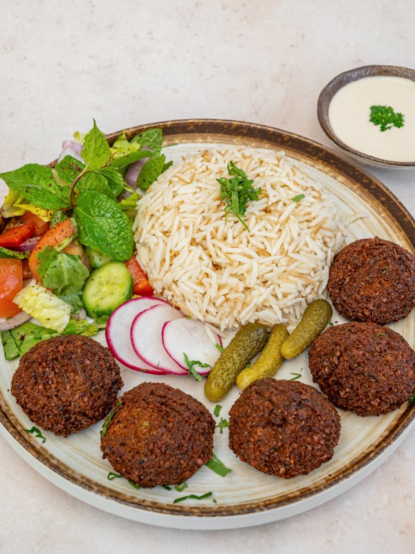 Falafel plate with rice, fresh salad, pickles and tahini sauce