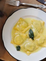Instagram post: ravioli with butter and sage on a white plate